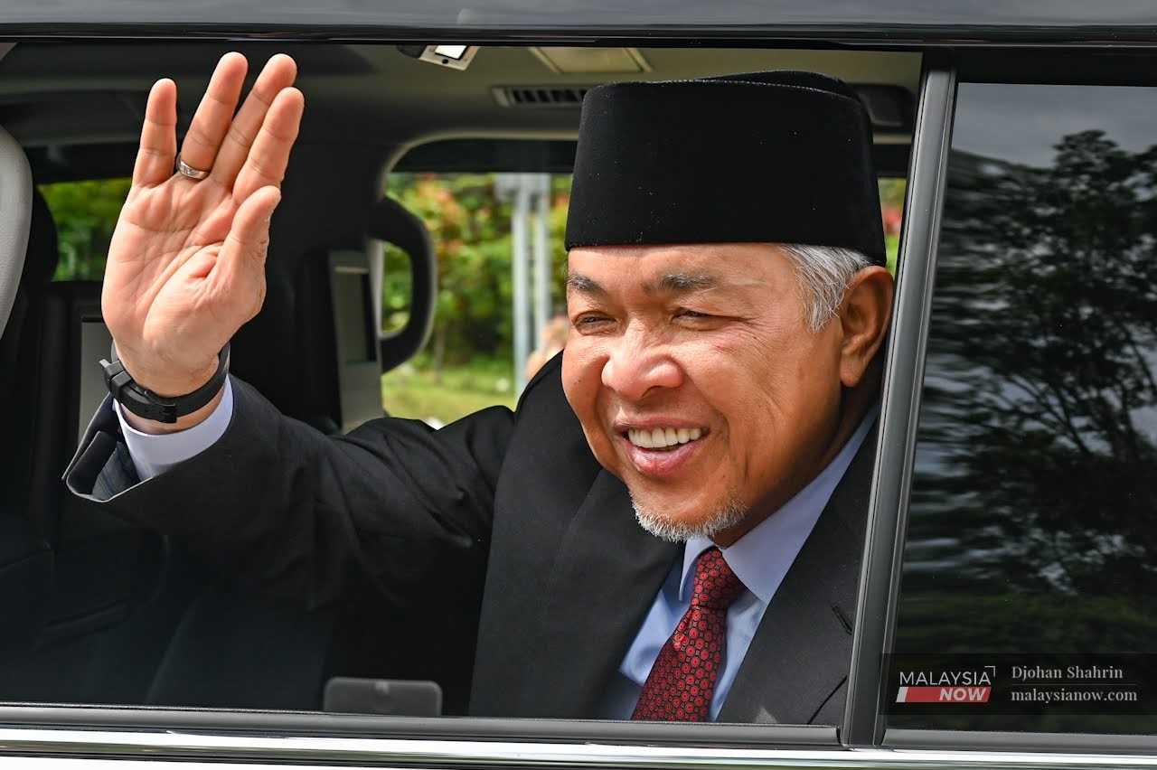 Umno president Ahmad Zahid Hamidi waves at reporters as he leaves Istana Negara after an audience with the Yang di-Pertuan Agong on Nov 23. 
