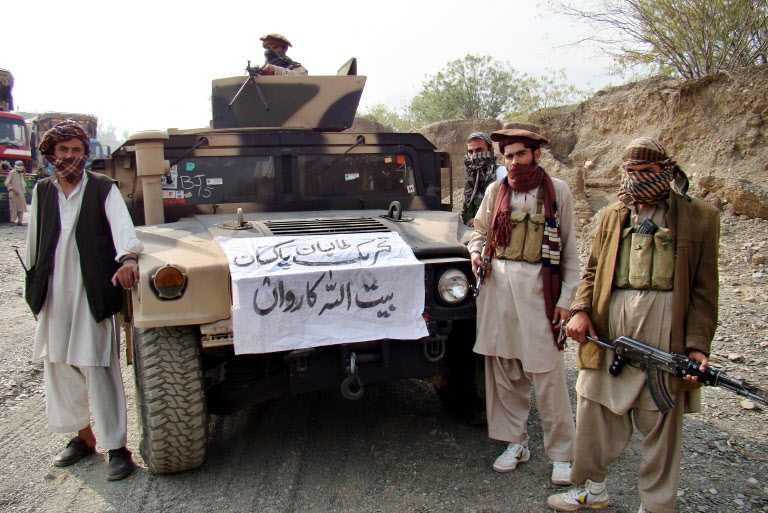 Armed militants of Tehreek-e-Taliban Pakistan pose for photographs next to a captured armored vehicle in the Pakistan-Afghanistan border town of Landikotal on Nov 10, 2008. Photo: AFP
