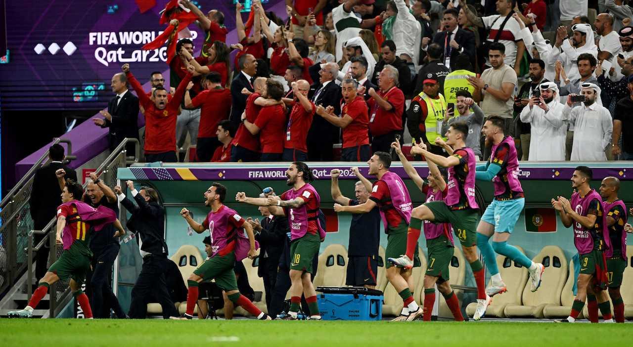 Portugal players celebrate on the bench after Bruno Fernandes scores their second goal from the penalty spot. Photo: Reuters