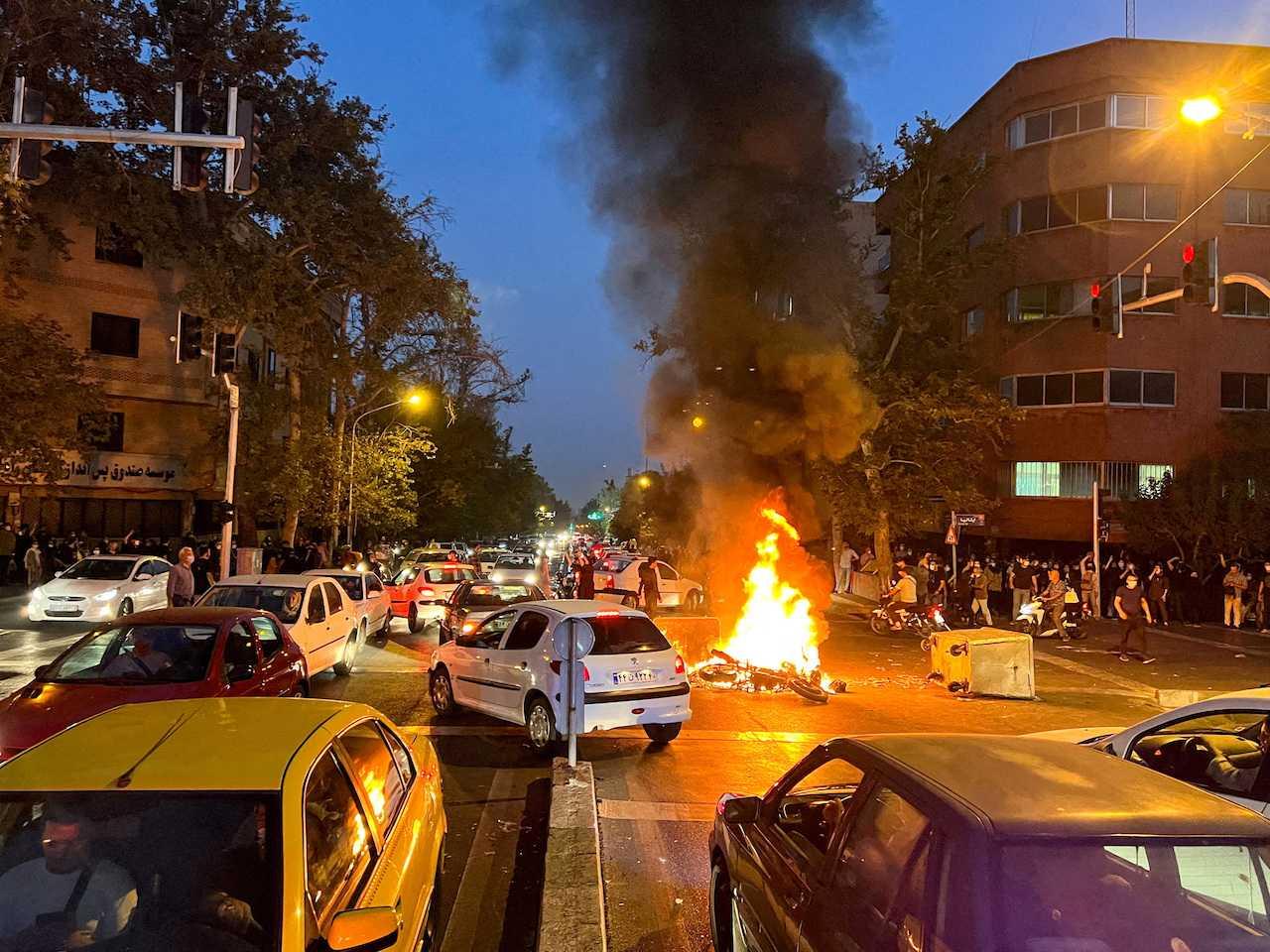 A police motorcycle burns during a protest over the death of Mahsa Amini, a woman who died after being arrested by the Islamic republic's 'morality police', in Tehran, Iran Sept 19. Photo: Reuters