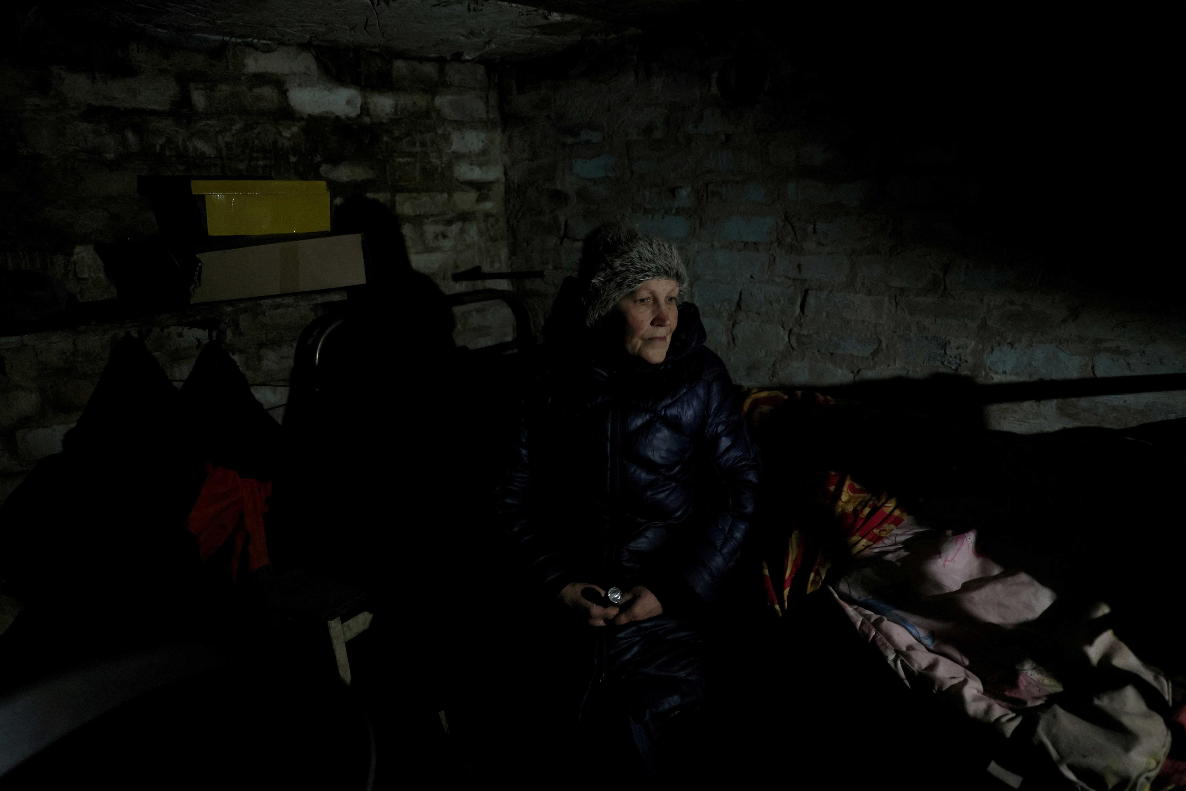 A woman sits for a portrait in the storage cellar where she and her husband sleep in Siversk, Donetsk region, Ukraine, Nov 28. Photo: Reuters