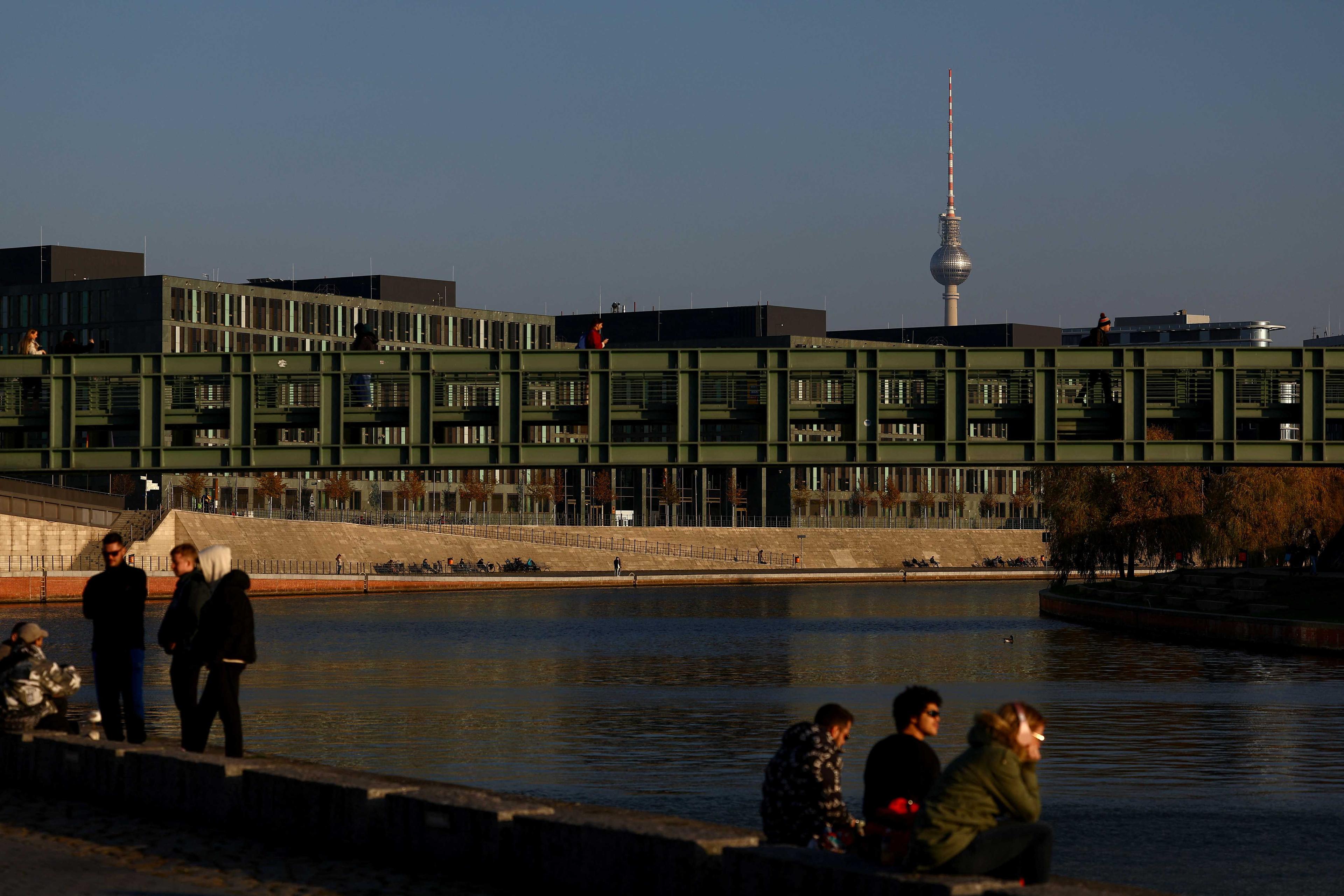 People sit at the banks of Spree River with the TV Tower in the background, on an autumn day, in Berlin, Germany, Nov 14. Photo: Reuters