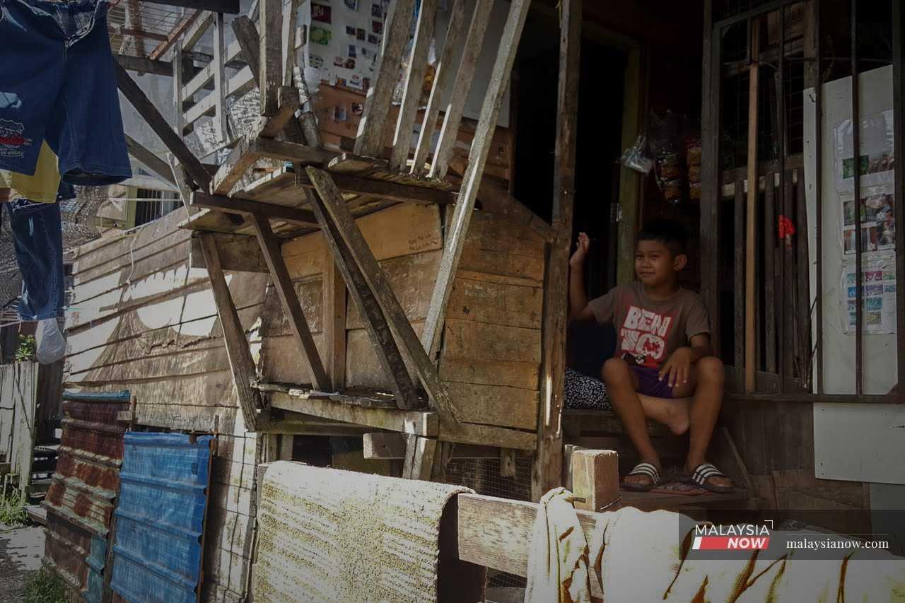 Seorang kanak-kanak tersenyum di beranda rumahnya di Sarawak dalam sebuah gambar fail. 