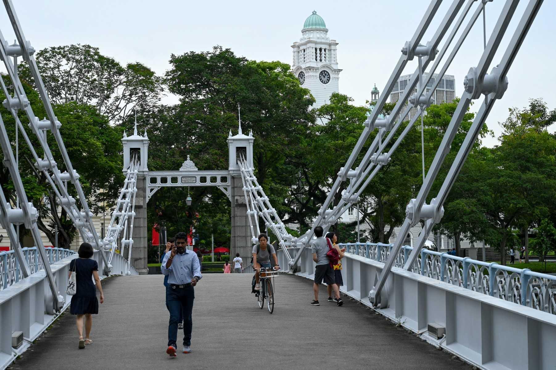 People walk across the Cavenagh bridge at Singapore's Civic District on Nov 1. Photo: AFP