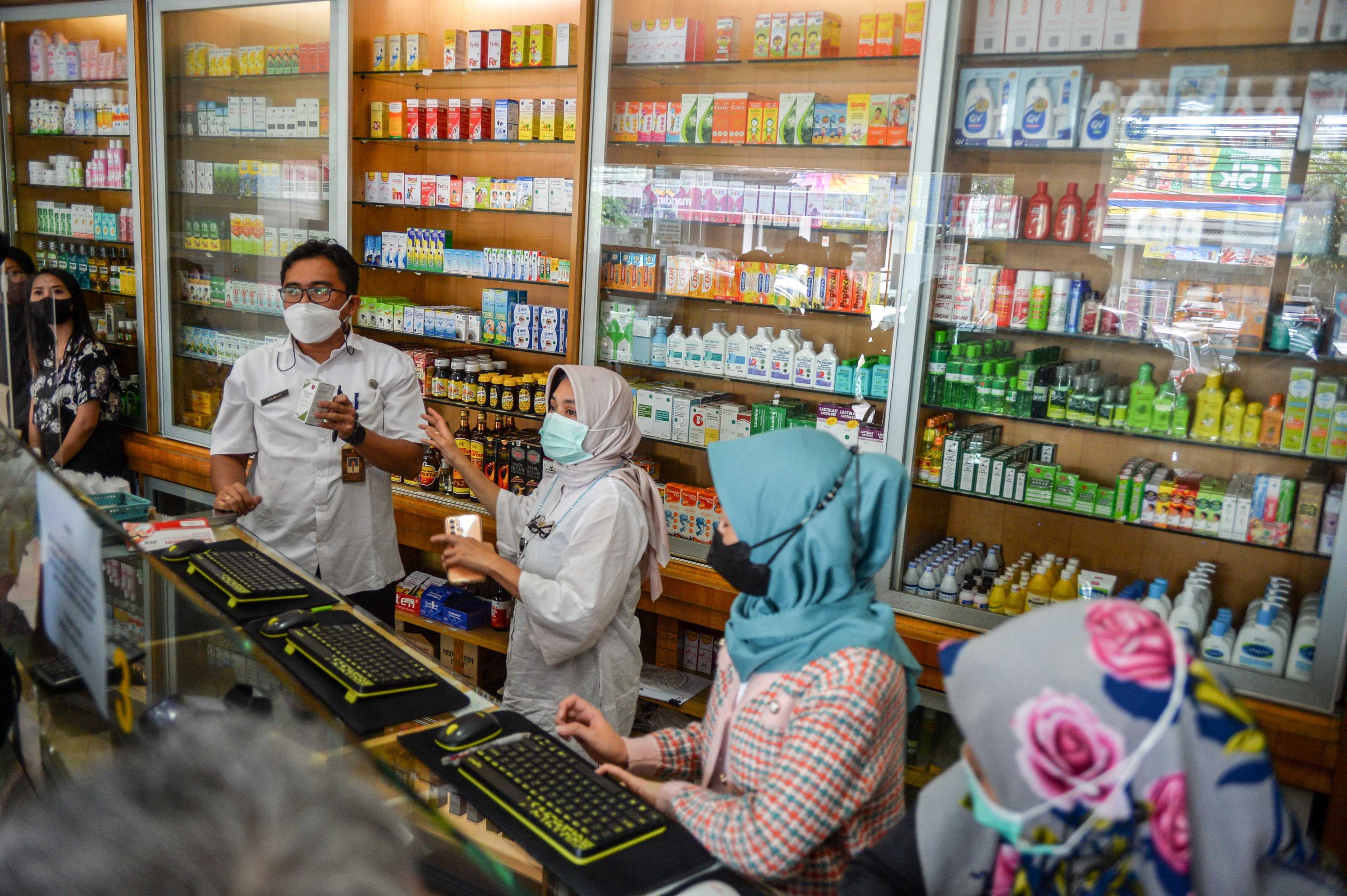 Health officers inspect medicinal syrups containing ethylene glycol and diethylene glycol at a pharmacy in Bandung, West Java province, Indonesia, Oct 26, in this photo taken by Antara Foto. Photo: Reuters