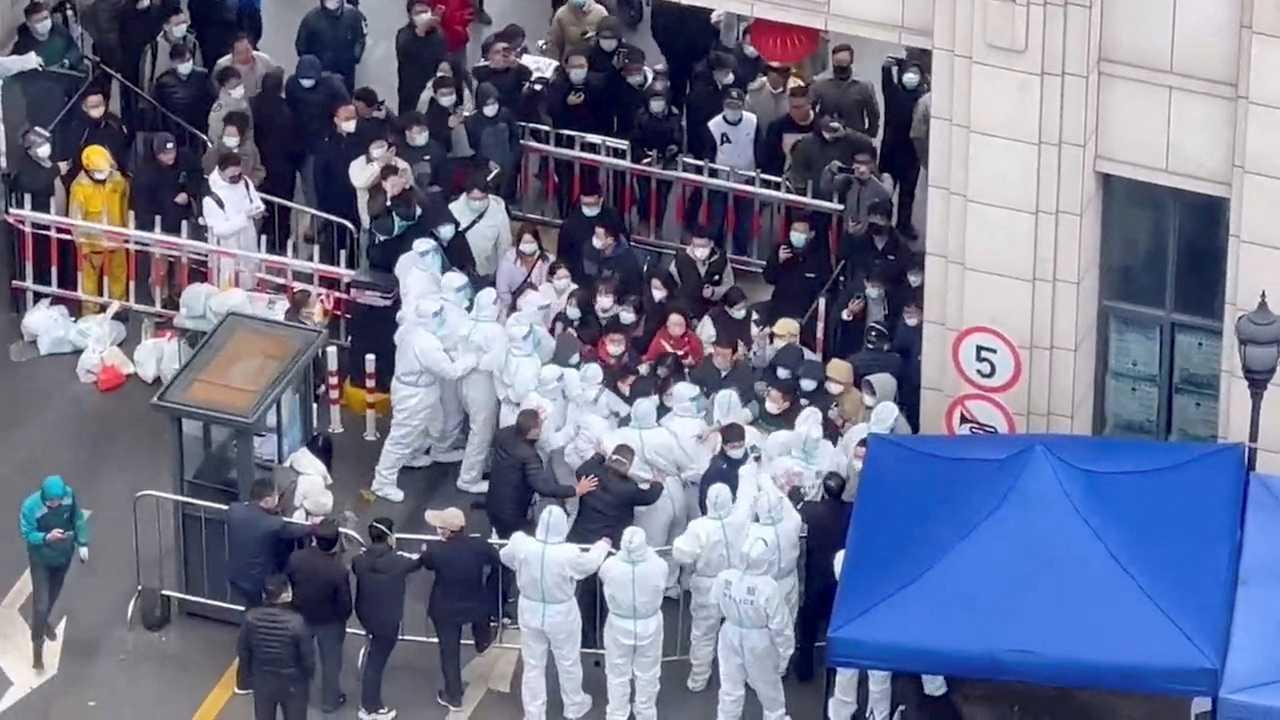Residents confront workers wearing protective suits who are blocking the entrance of a residential compound, amid the Covid-19 outbreak in Shanghai, China, in this still image obtained from a social media video released Nov 30. Photo: Reuters
