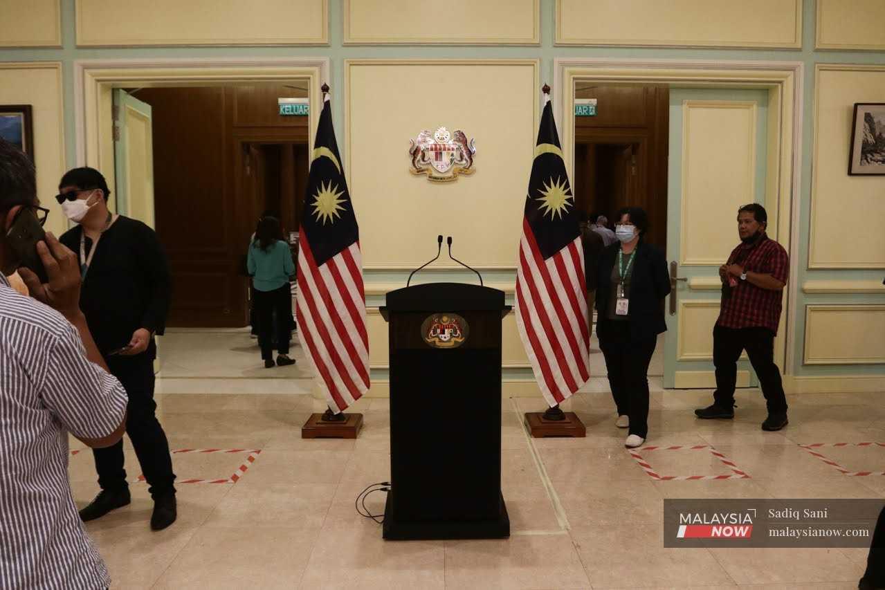Wartawan menunggu berhampiran podium kosong untuk sidang media Perdana Menteri Anwar Ibrahim di Perdana Putra, Putrajaya hari ini.