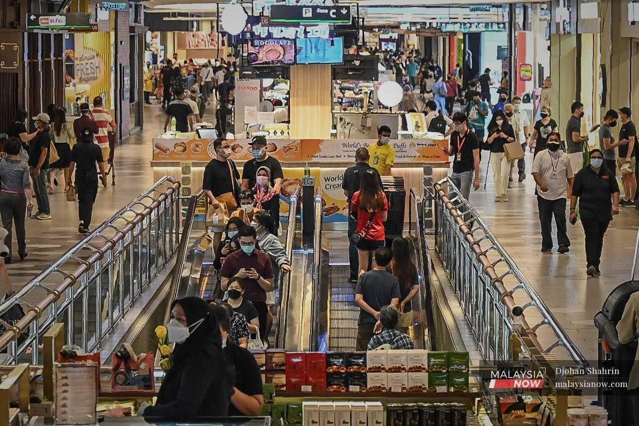 People wearing face masks stroll about in a shopping mall in Kuala Lumpur.