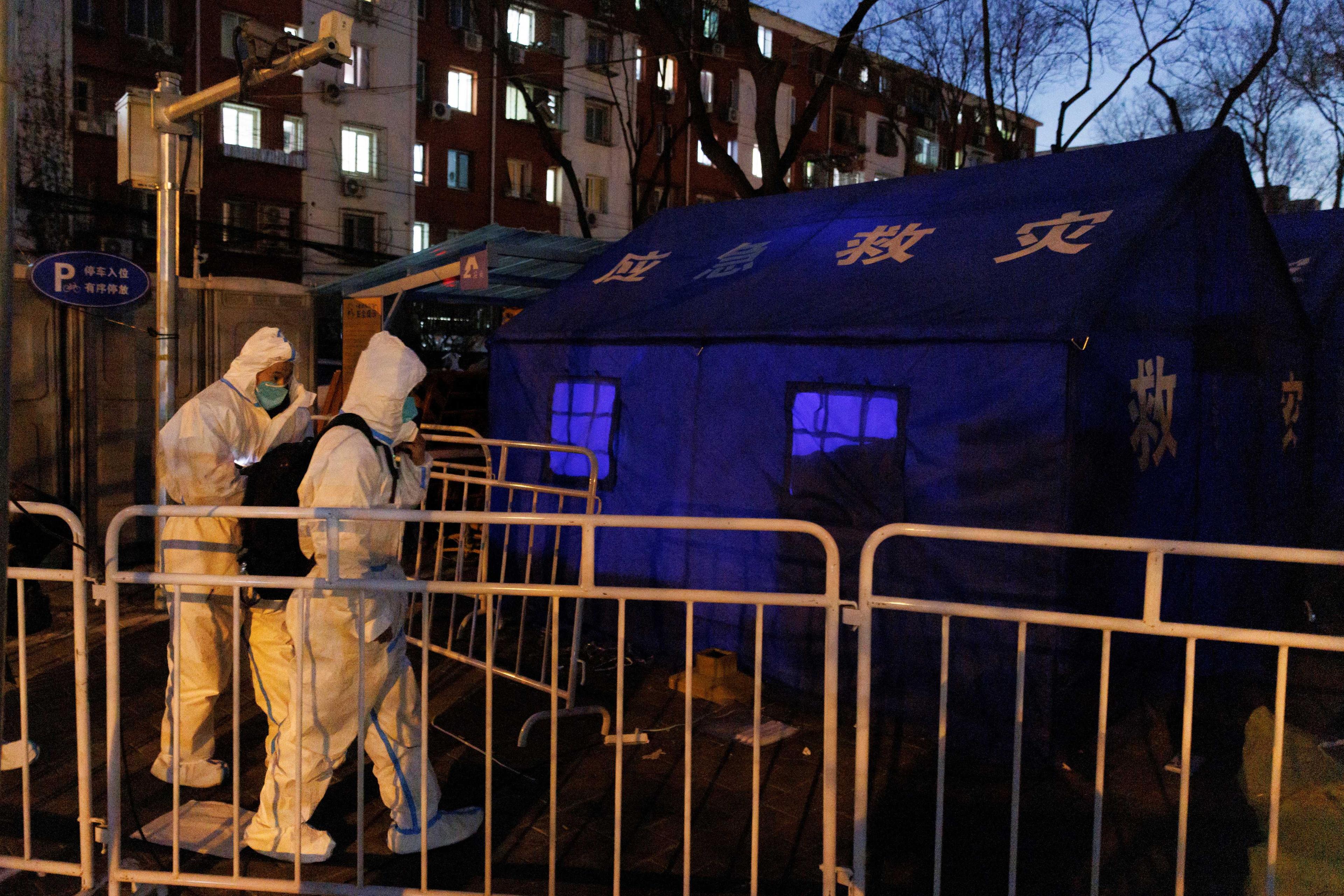 Pandemic prevention worker in protective suits approach tents that serve as their living quarters as Covid-19 outbreaks continue in Beijing, Dec 4. Photo: Reuters