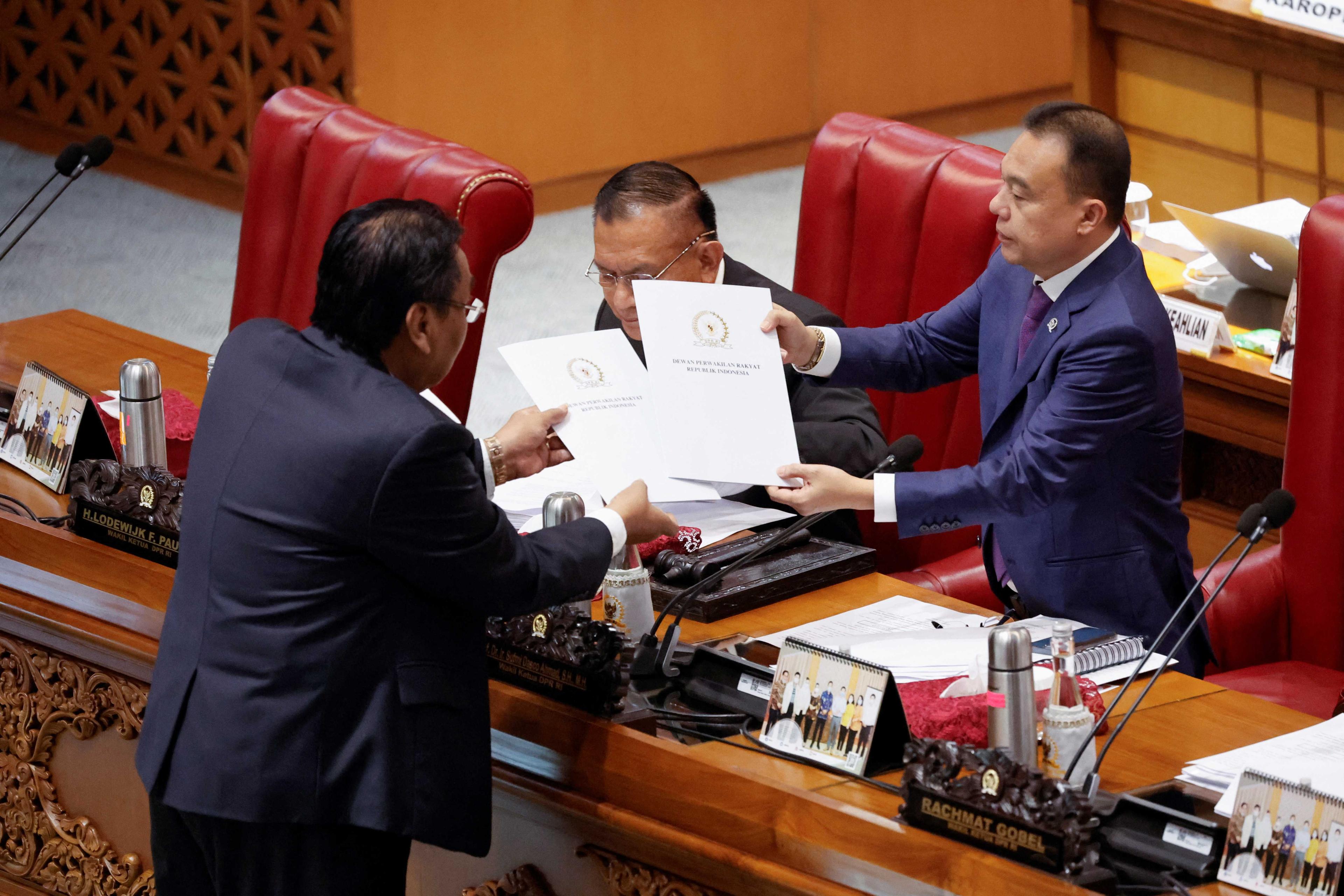 Bambang Wuryanto, head of the parliamentary commission overseeing the revision, passes the report of the new criminal code to Sufmi Dasco Ahmad, Deputy speaker of the House of Representatives, during a parliamentary plenary meeting in Jakarta, Indonesia, Dec 6. Photo: Reuters