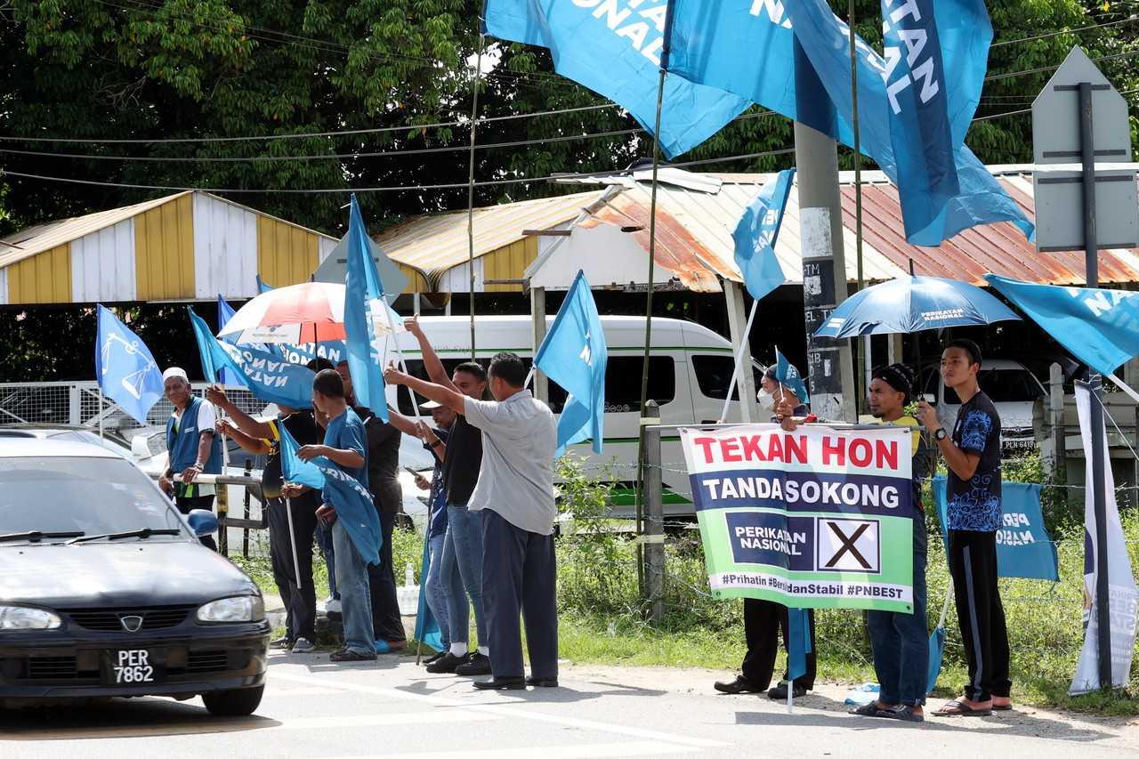 Perikatan Nasional supporters wave party flags in Kulim earlier today. Photo: Bernama