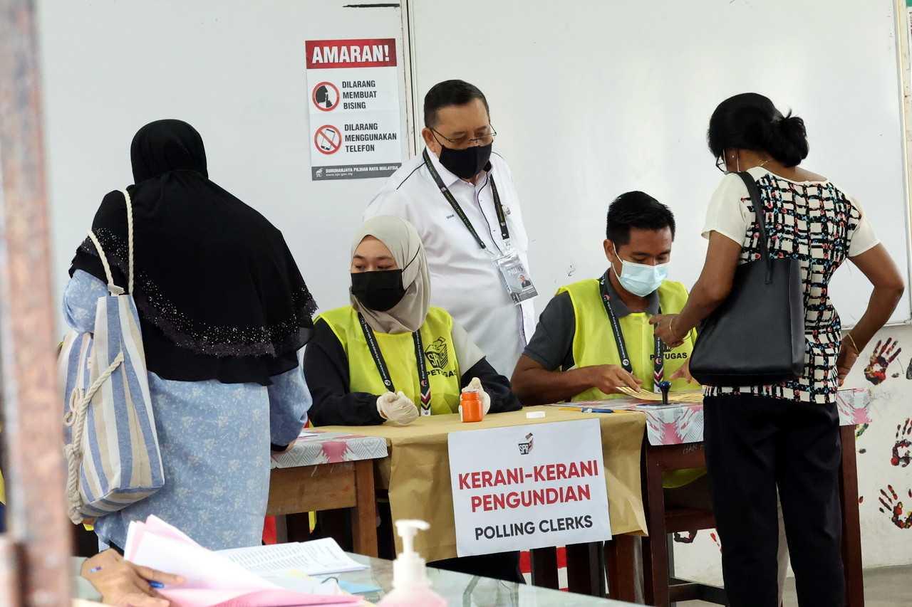 Election Commission chairman Abdul Ghani Salleh (centre) checks the election process at the SMK Sultan Badlishah polling centre in Kulim today. Photo: Bernama