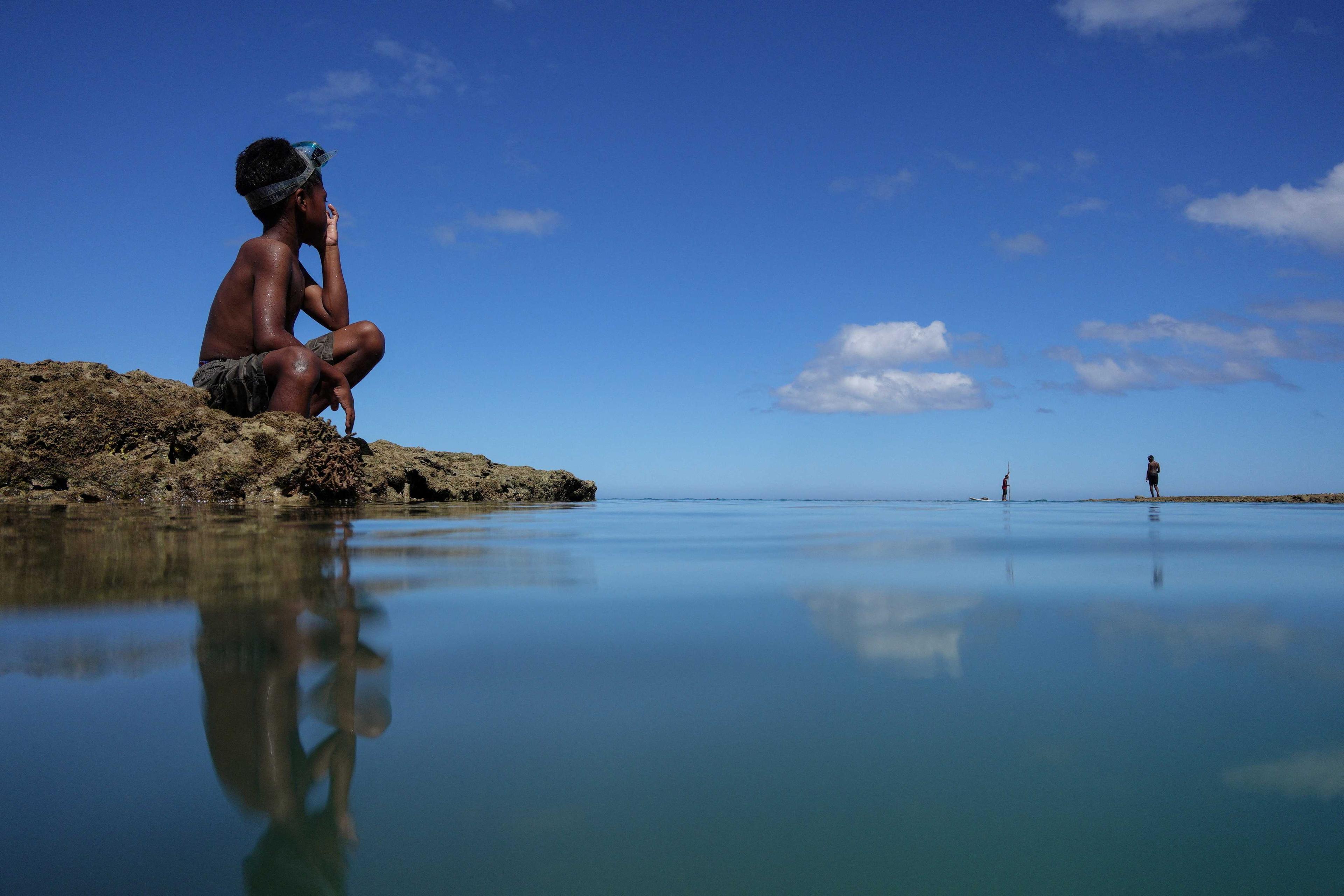 A boy takes a break from diving in the sea at Serua Village, Fiji, July 14. Photo: Reuters