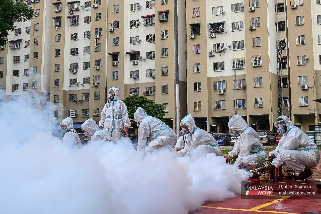 Volunteers carry out fogging activities to prevent Aedes mosquitoes from breeding at a low-cost flat in Kuala Lumpur, in this file picture. 