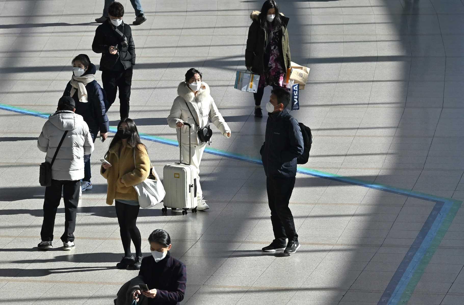 People wearing face masks walk through a railway station in Seoul on Feb 18. Photo: AFP
