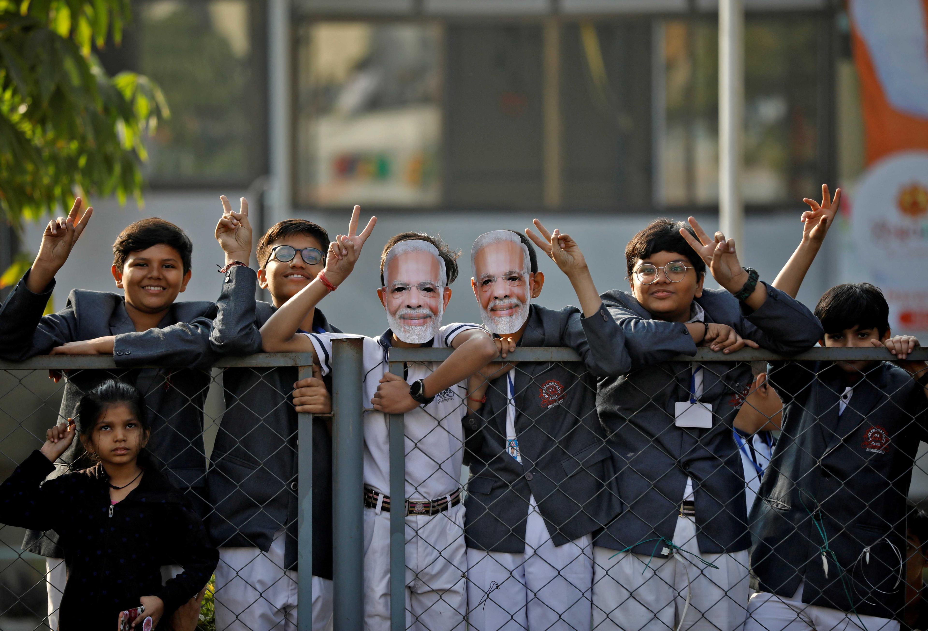School children gesture towards India's Prime Minister Narendra Modi as he arrives to cast his vote during the second and last phase of Gujarat state assembly elections in Ahmedabad, India, Dec 5. Photo: Reuters
