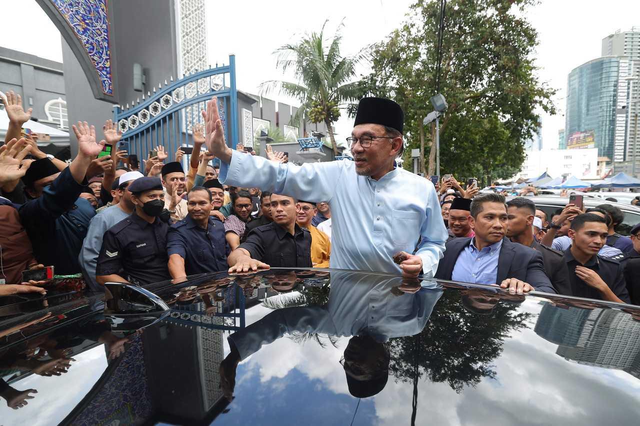 Prime Minister Anwar Ibrahim waves as he leaves Masjid Jamek Kampung Baru in Kuala Lumpur today. Photo: Bernama