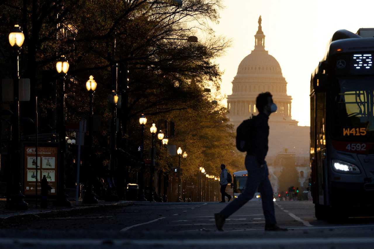 A pedestrian crosses Pennsylvania Avenue as the sun rises over the US Capitol in Washington, US, Nov 9. Photo: Reuters