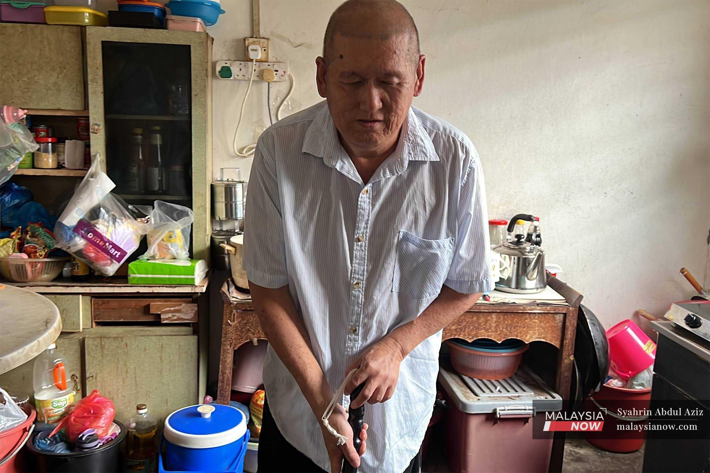 Bekas pengawal keselamatan Lim Bun Lai yang buta akibat diabetes, menggunakan tongkat di rumahnya di Padang Terap, Kedah.