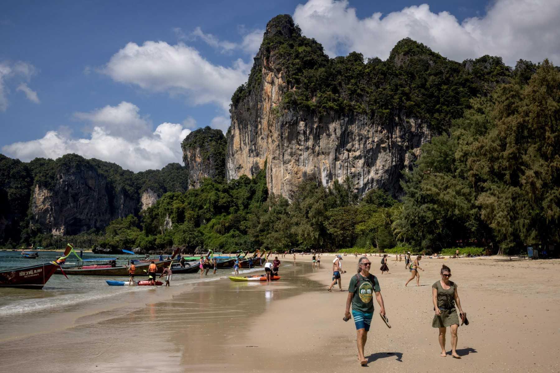 Tourists walk along a beach in Railay, Krabi, in this photo taken on Dec 7. Photo: AFP