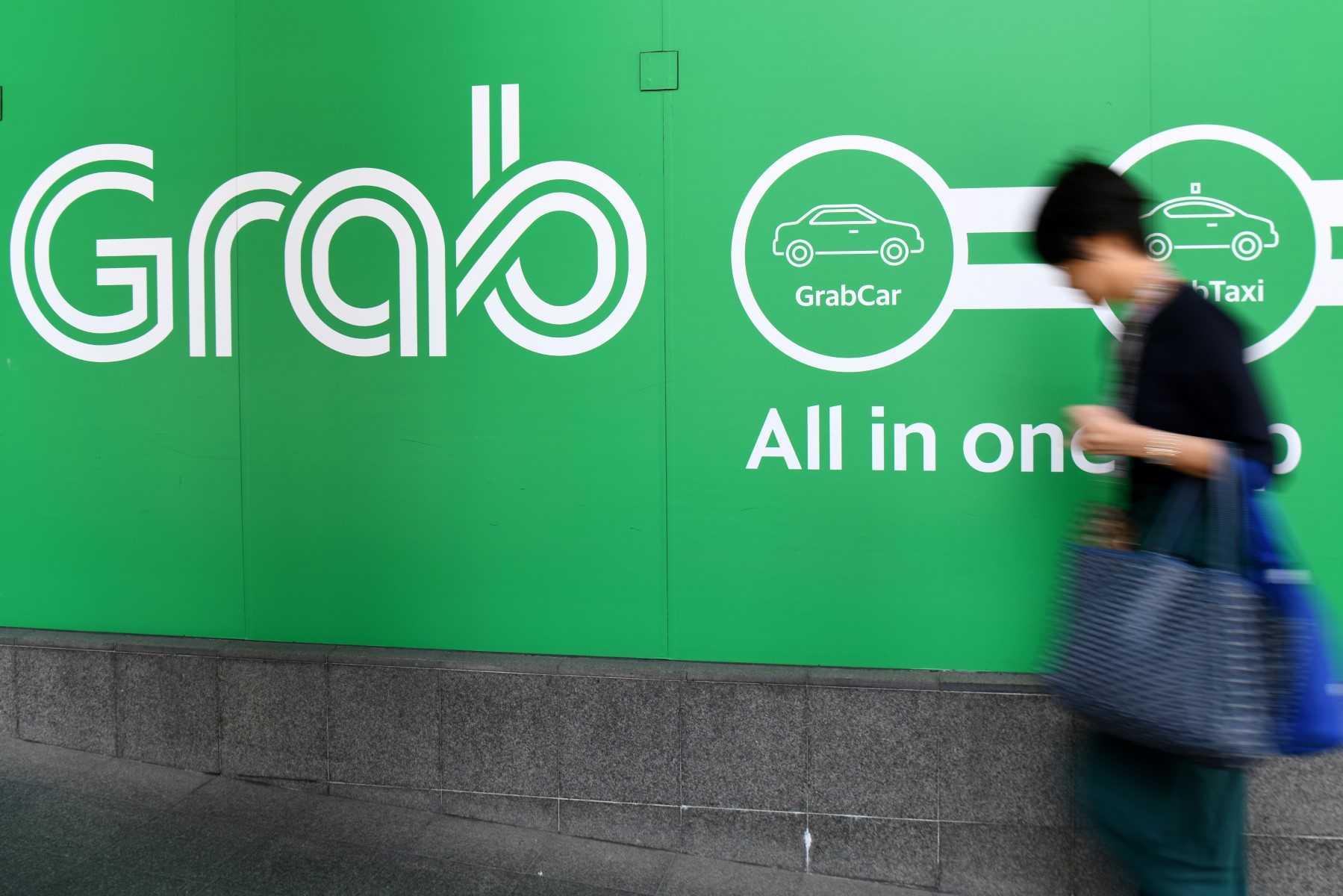 A woman walks past the Grab transport office in Singapore on Sept 24, 2018.  Photo: AFP