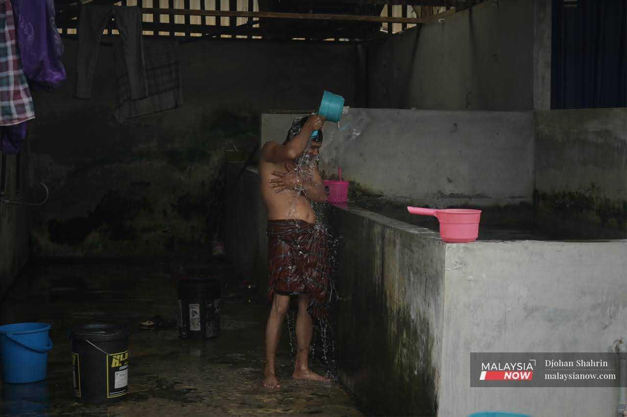 Para pekerja membasuh baju dan mandi selepas seharian bekerja.