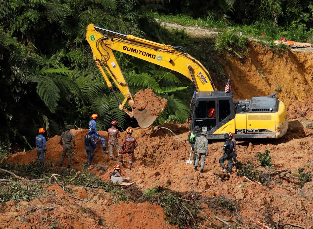 Anggota penyelamat menggunakan jengkaut dalam usaha mencari mangsa tanah runtuh di Batang Kali, Selangor pada 17 Disember. Gambar: Reuters