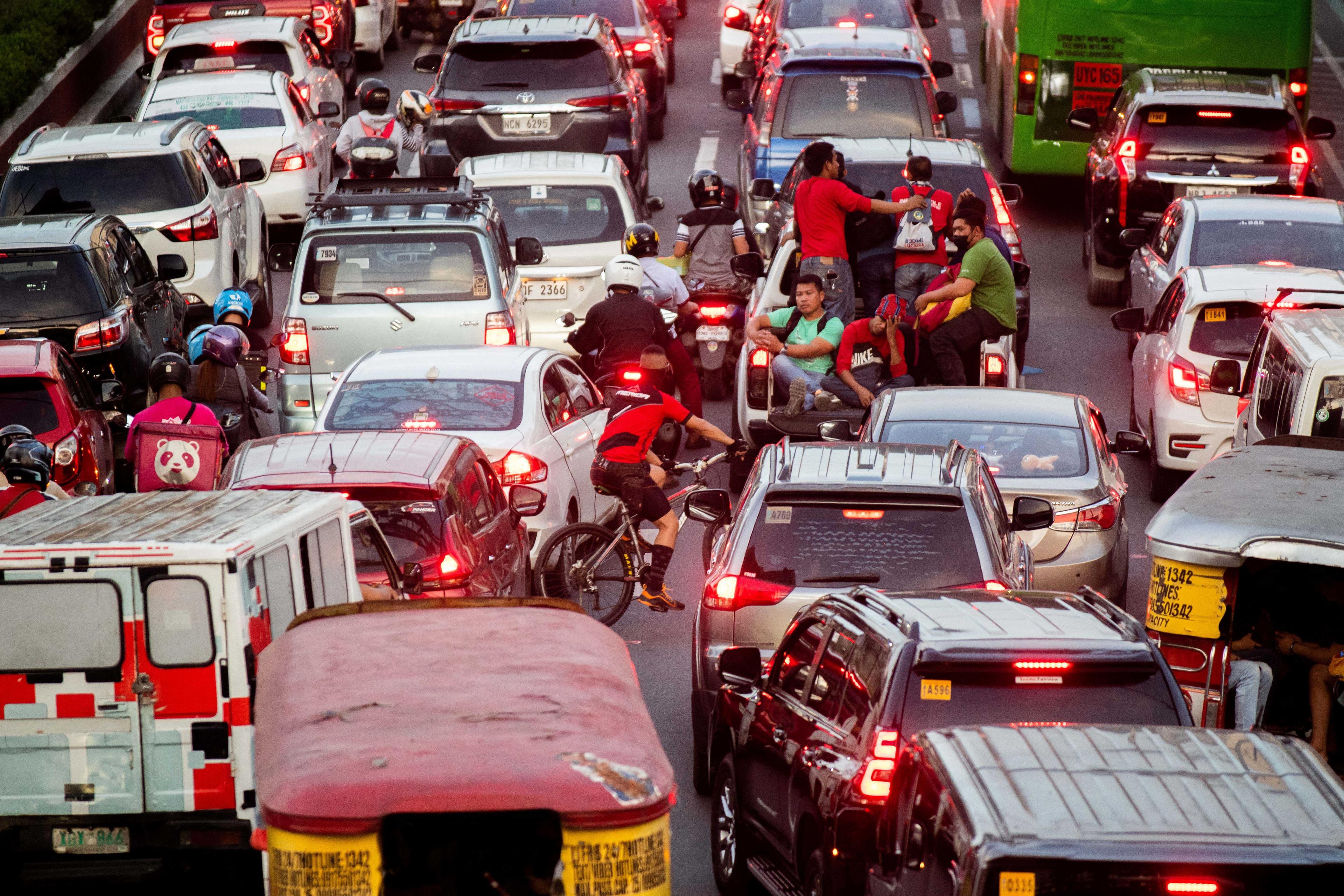 People ride at the back of a pickup car amid heavy traffic as Christmas nears, in Quezon City, Metro Manila, Philippines, Dec 16. Photo: Reuters