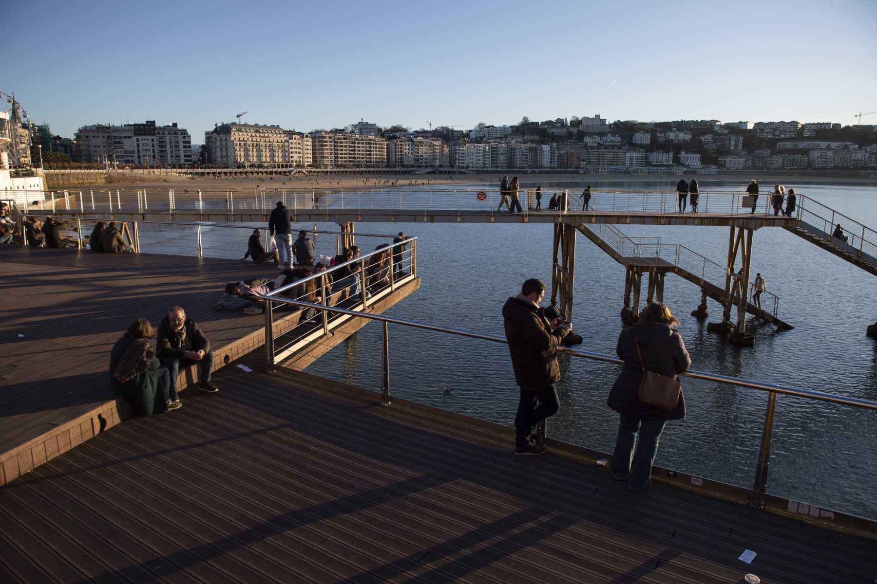 People look at the sunset in La Concha bay from the port of the Spanish Basque city of San Sebastian, on Dec 17. Photo: AFP