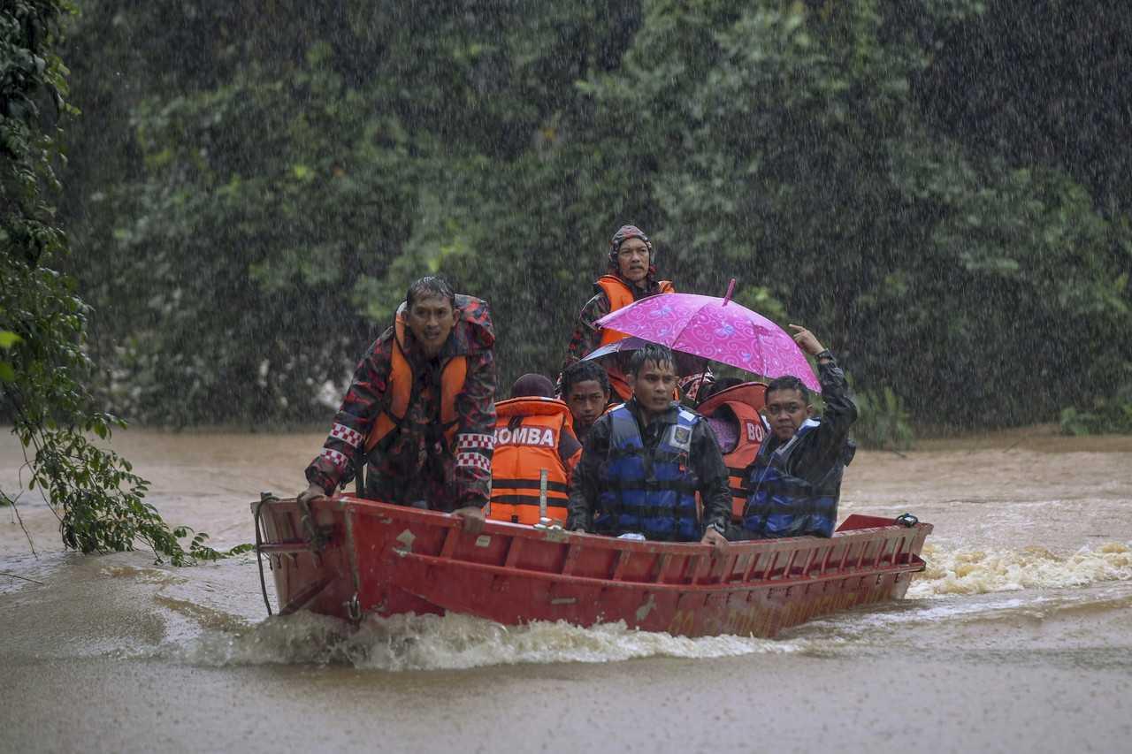 Rescue personnel evacuate flood victims during heavy rain in Kampung Kepah, Kuala Terengganu, on Dec 18. Photo: Bernama