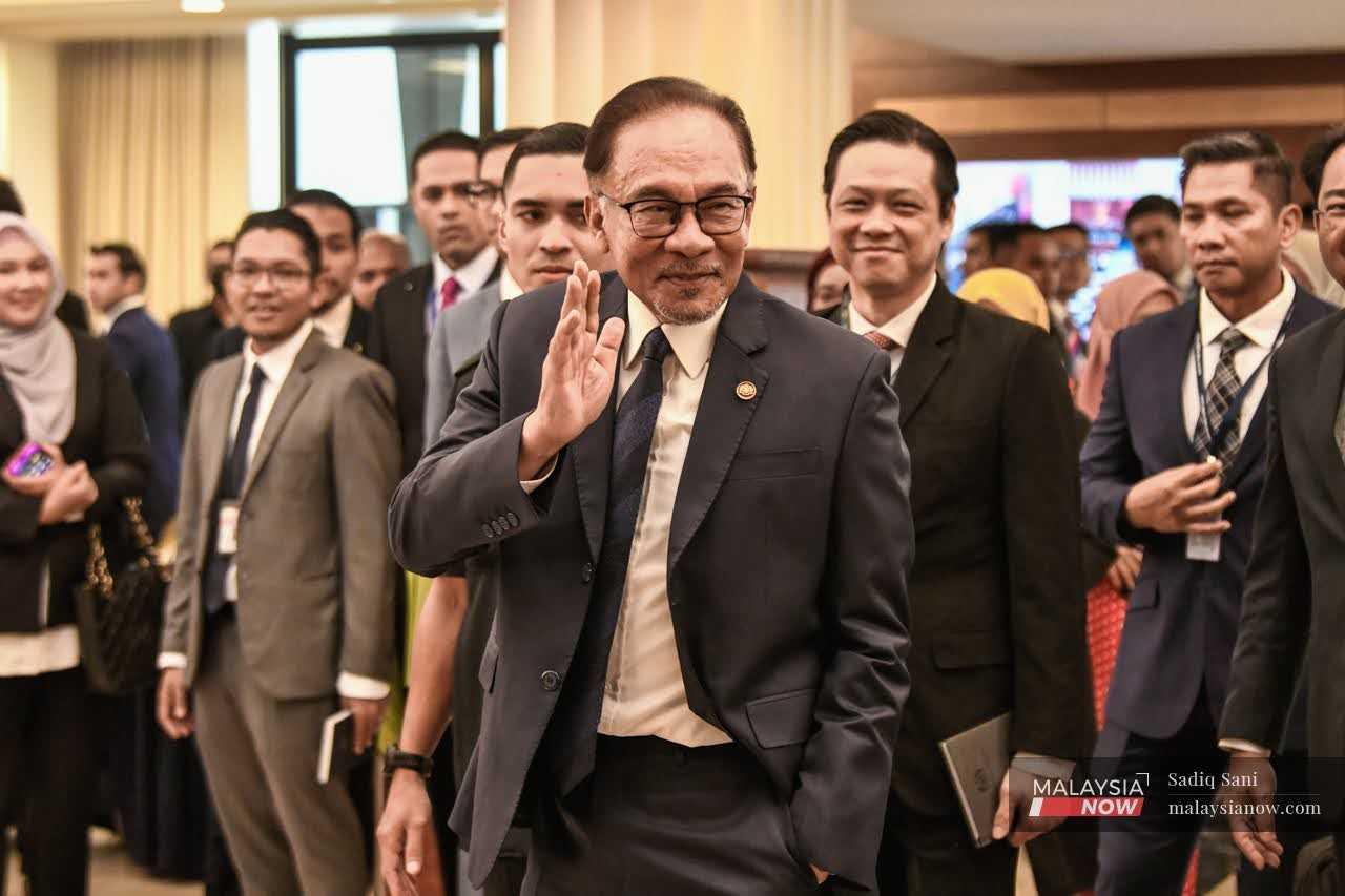 Prime Minister Anwar Ibrahim waves as he arrives at the Parliament building in Kuala Lumpur today.