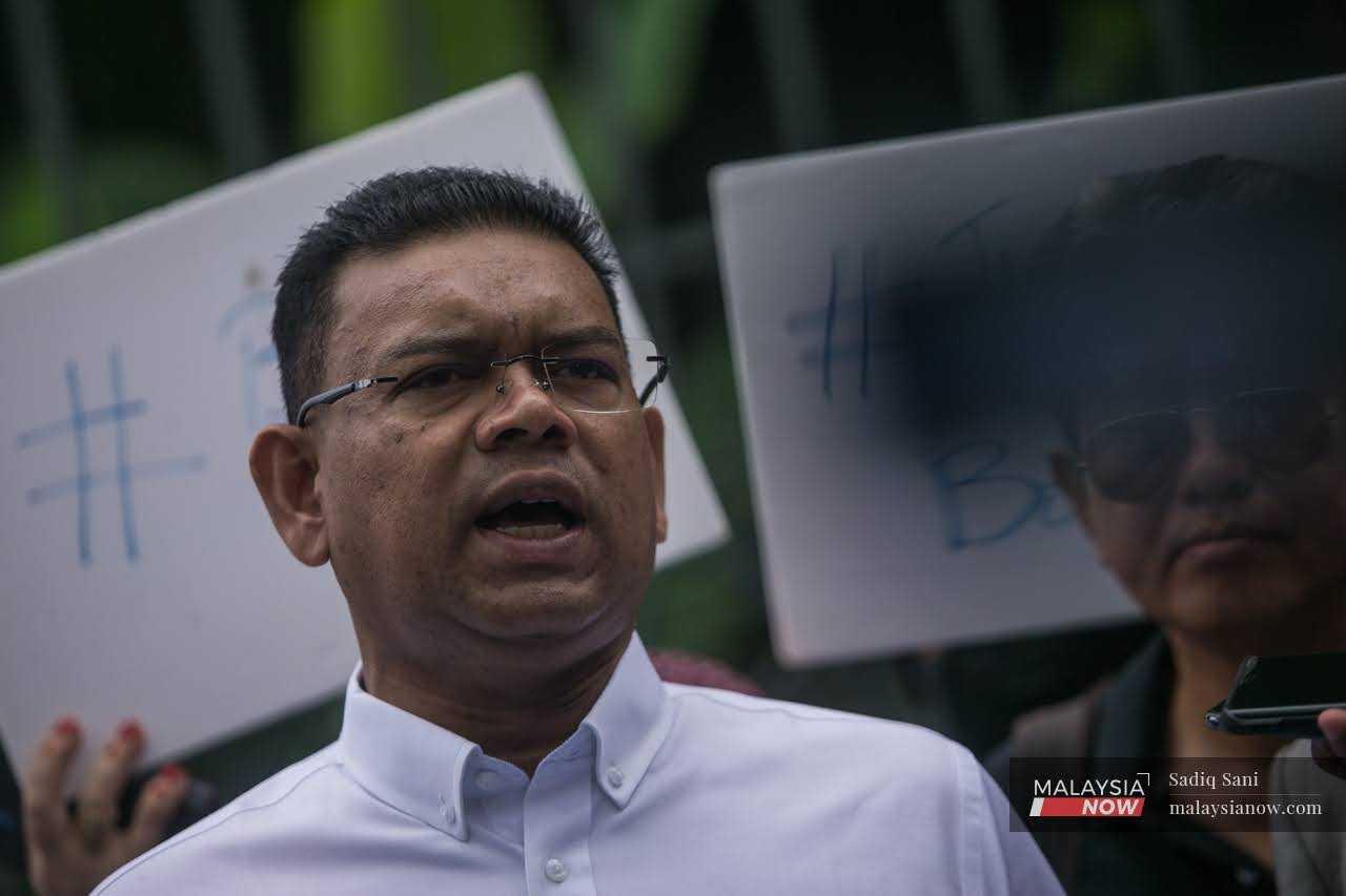 Former Umno Supreme Council member Lokman Noor Adam speaks before handing over a memorandum to the law minister outside the Parliament building in Kuala Lumpur today.