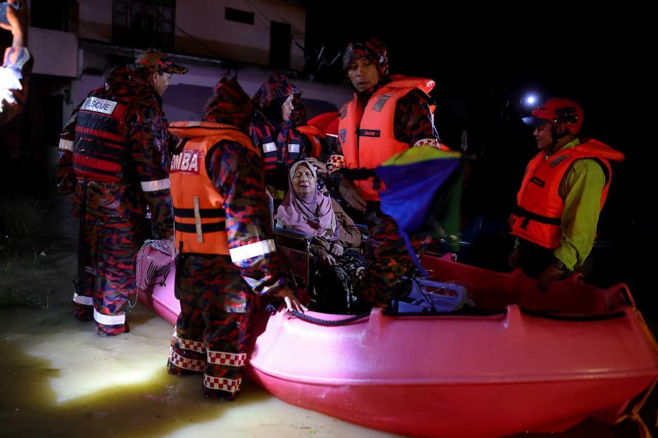 Anggota penyelamat memindahkan mangsa banjir di Kampung Pulau Rusa Hulu, Kuala Terengganu pada 19 Disember. Gambar: Bernama