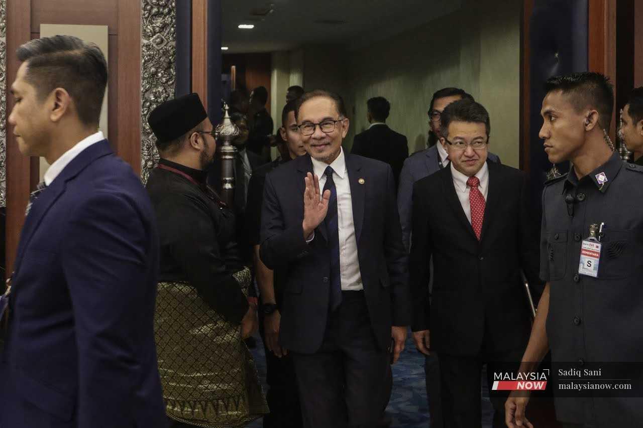 Prime Minister Anwar Ibrahim waves as he leaves the Dewan Rakyat in Kuala Lumpur, Dec 19. 
