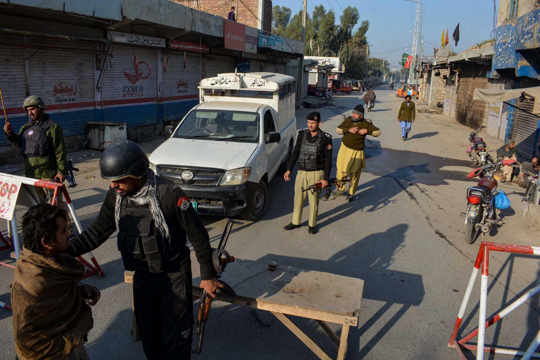 Police stand guard along a road they blocked after Taliban militants seized a police station in Bannu on Dec 19. Photo: AFP 