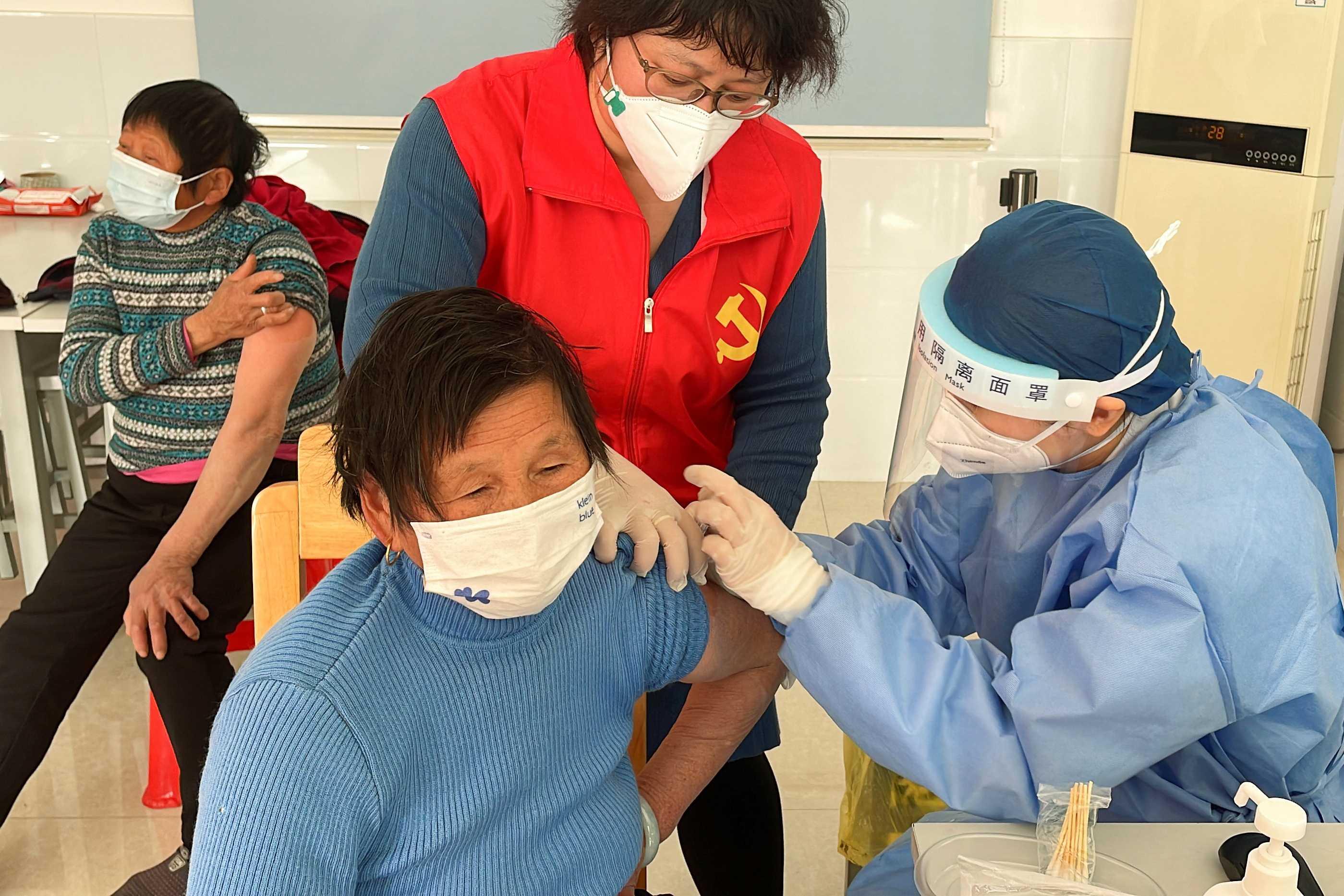 A medical worker administers a dose of a vaccine against Covid-19 to an elderly resident, during a government-organized visit to a vaccination center in Zhongmin village on the outskirts of Shanghai, China Dec 21. Photo: Reuters