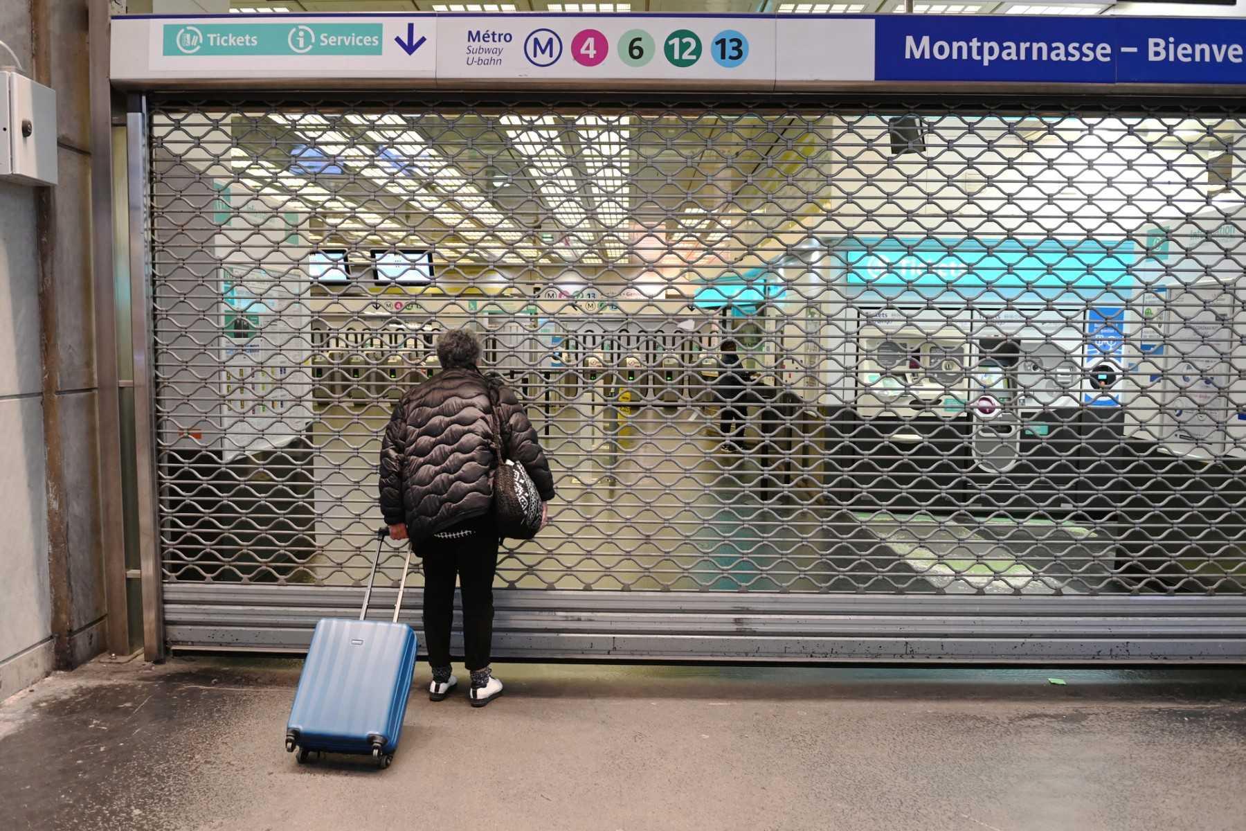A commuter stands near the closed gate of the Montparnasse - Bienvenue metro station in Paris on Nov 10. Photo: AFP