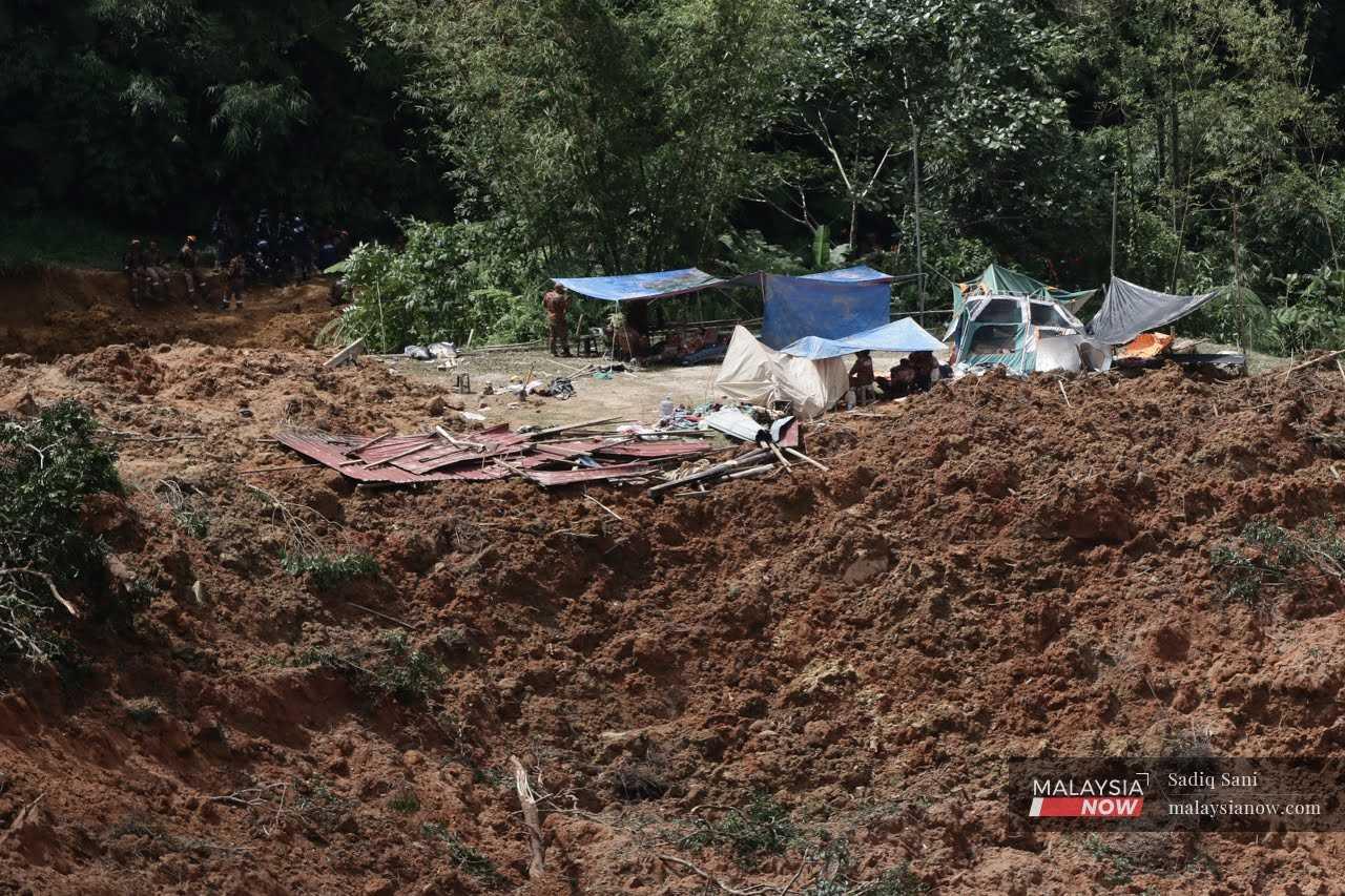 Rescue workers carry out a search and rescue operation at the site of a landslide at a campsite at the Father's Organic Farm in Batang Kali, Dec 16.