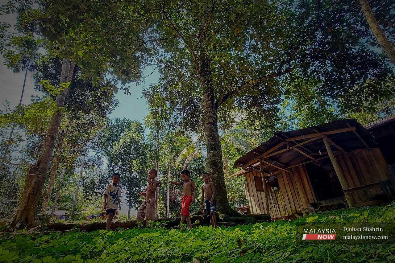 Anak Orang Asli dari komuniti Jakun di luar rumah mereka di Kampung Tanjung Puput, Tasik Chini, Pahang.