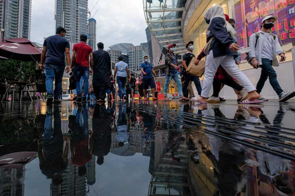 Pedestrians cross a road in the Bukit Bintang shopping district in Kuala Lumpur. Lifestyle choices have been identified as some of the factors for cancer, more cases of which are being detected in the country. Photo: Bernama