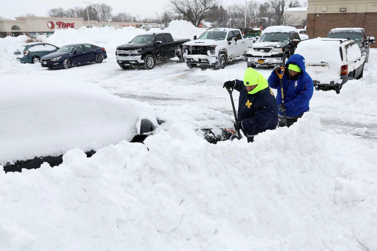 People work to dig out a car during a winter storm that hit the Buffalo region, in Amherst, New York, Dec 26. Photo: Reuters