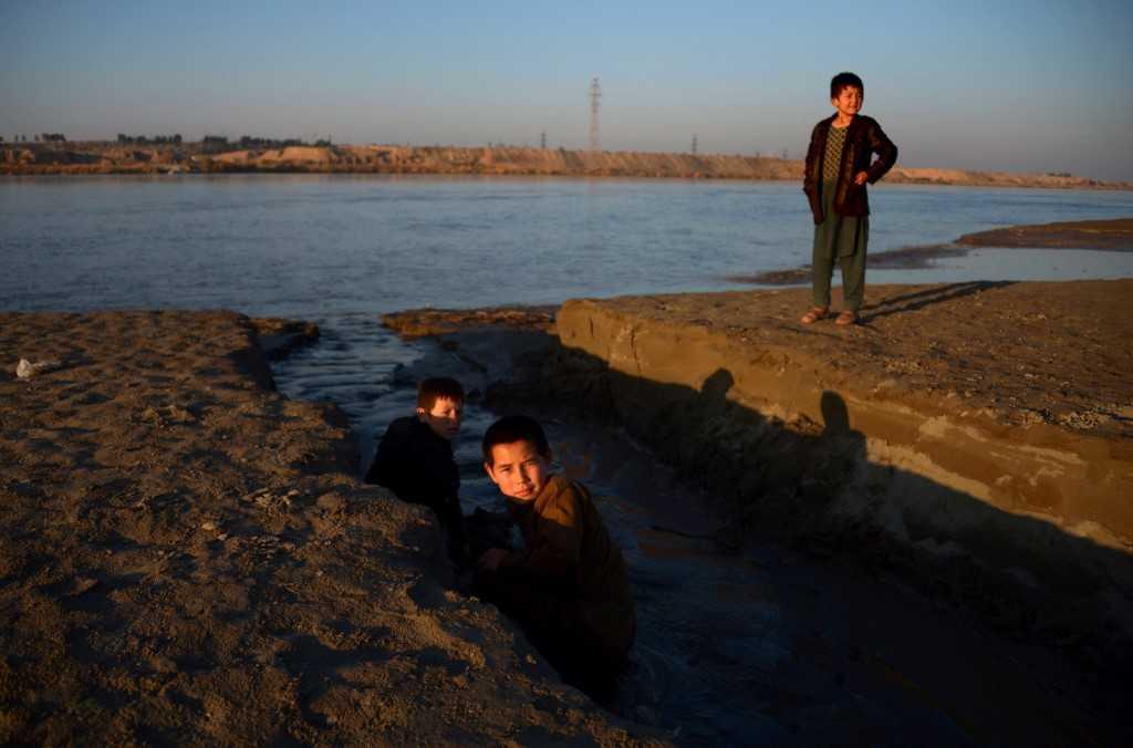 In this photograph taken on Nov 30, 2015, Afghan children play alongside the Amu River on the border of Afghanistan and Uzbekistan. Photo: AFP