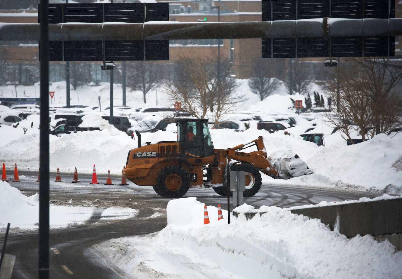 A worker uses heavy machinery to remove snow at Buffalo Niagara International Airport, following a deadly Christmas blizzard, in Cheektowaga, New York, Dec 27. Photo: Reuters