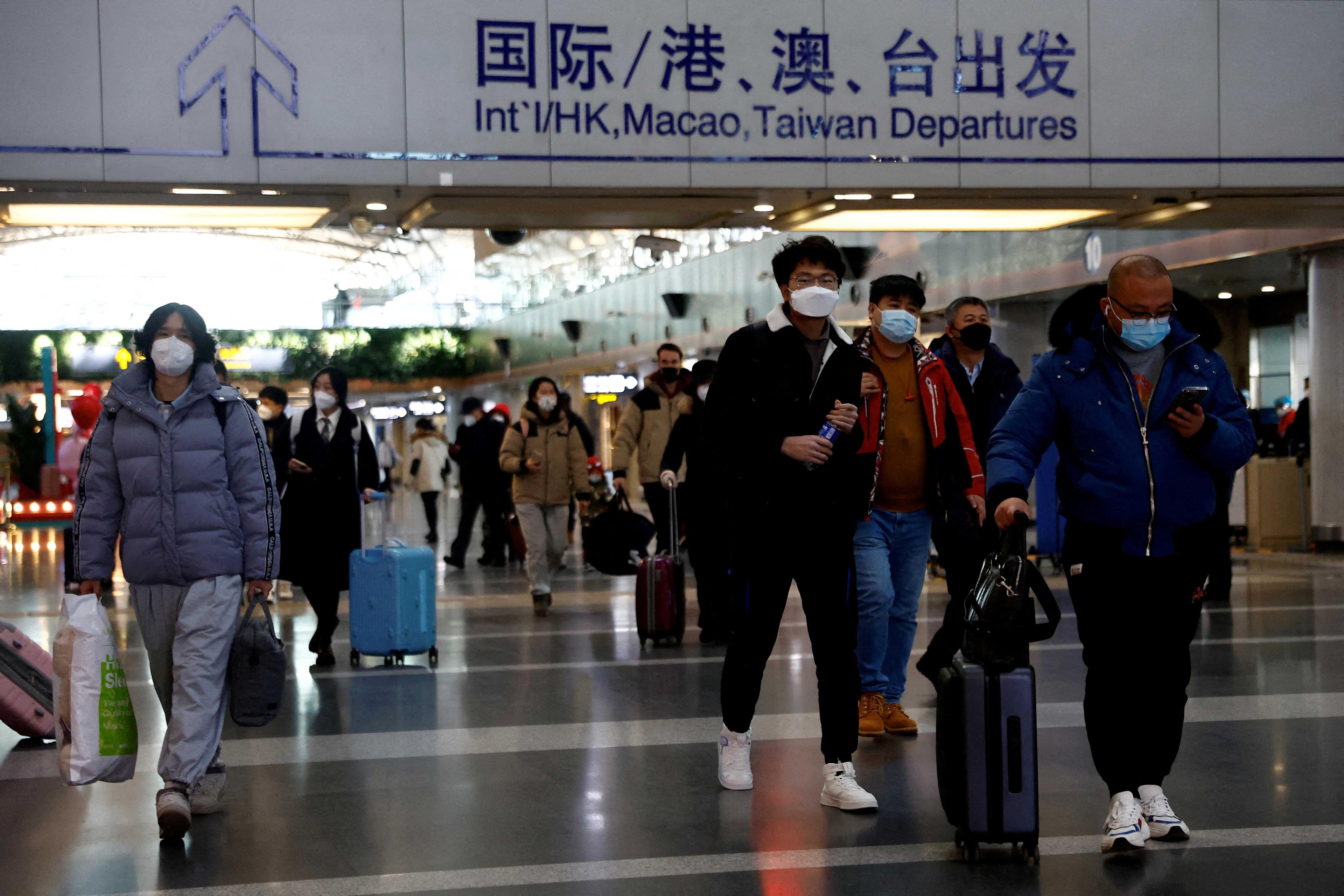 Travellers walk with their luggage at Beijing Capital International Airport, amid the Covid-19 outbreak in Beijing, China Dec 27. Photo: Reuters
