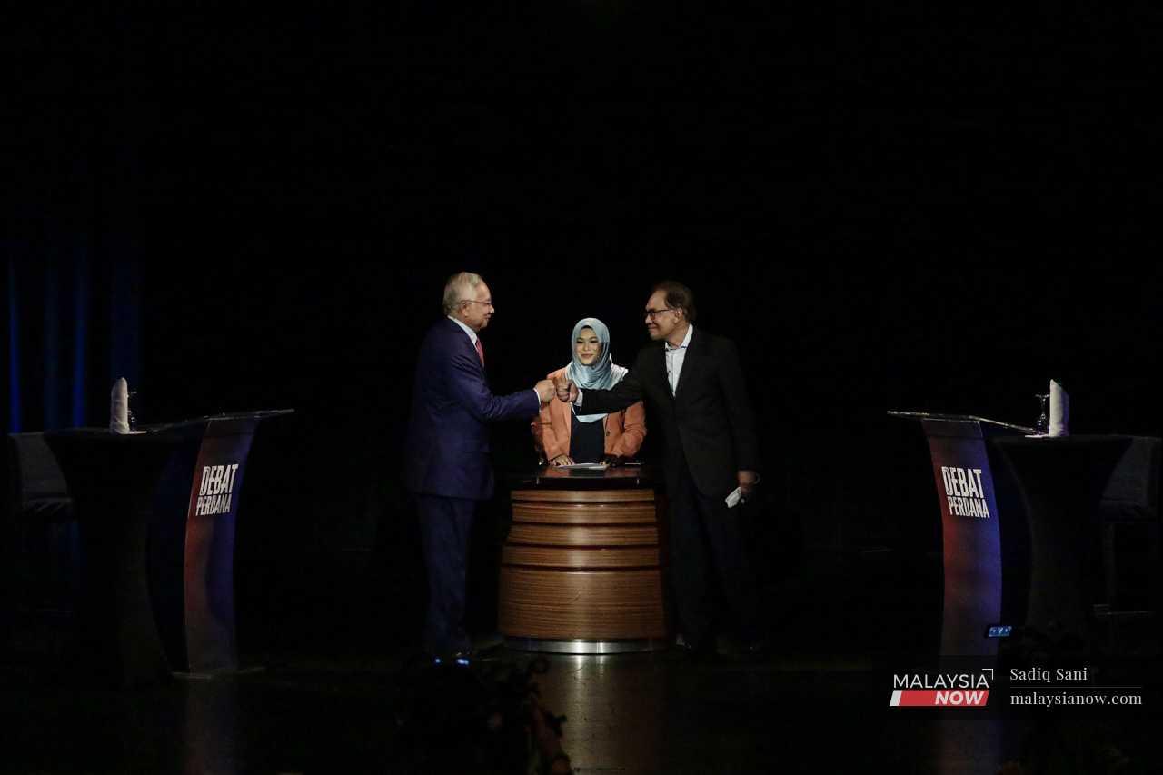 Former prime minister Najib Razak (left) bumps fists with then opposition leader Anwar Ibrahim during the Perdana Debate in Kuala Lumpur on May 12. 