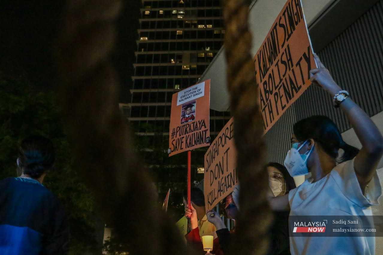 Protesters hold up placards urging Singapore to abolish its death penalty during a candlelight vigil in front of the Singapore high commission in Kuala Lumpur, amid the city-state's spree of executions. 