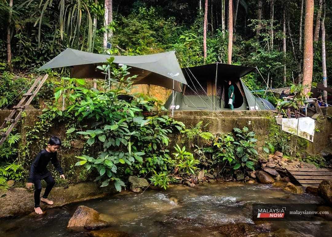 Suhaida Mat Jusoh keeps an eye on one of her children at a campsite in Labis, Johor, in July 2022.