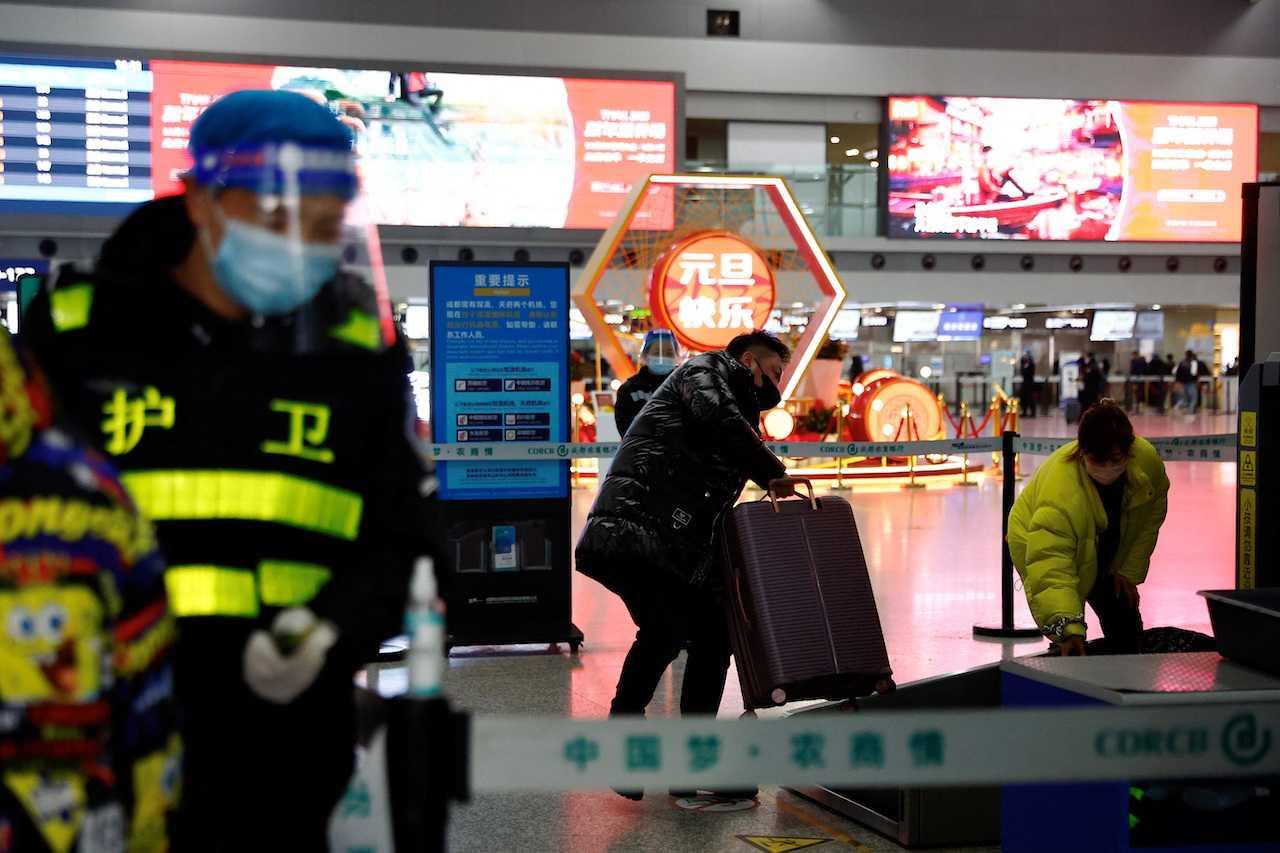 A traveller holds his luggage at a checkpoint at Chengdu Shuangliu International Airport amid a wave of Covid-19 infections, in Chengdu, Sichuan province, Dec 30, 2022. Photo: Reuters