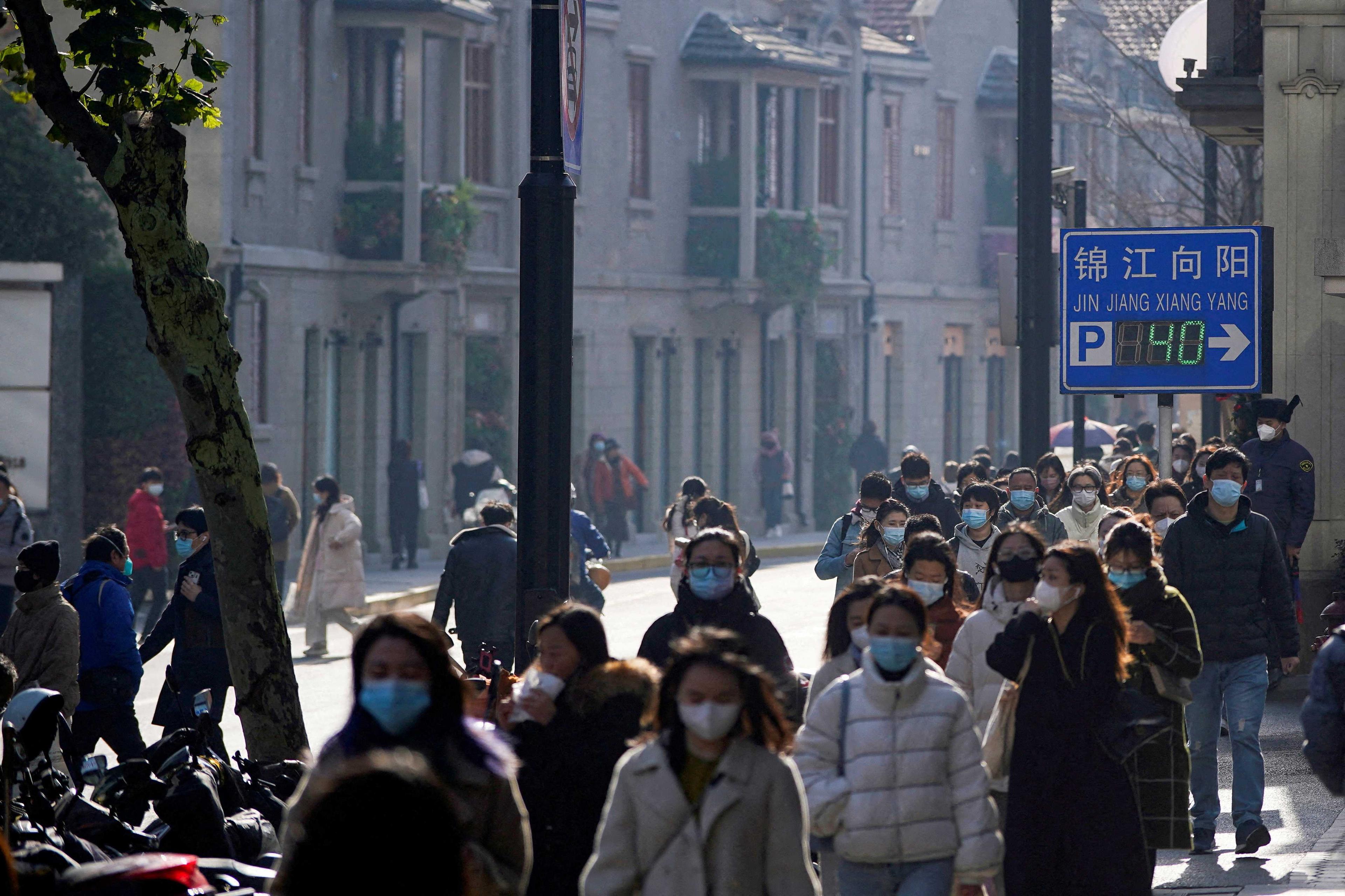 People wearing face masks walk on a street, as Covid-19 outbreaks continue in Shanghai, China, Dec 13, 2022. Photo: Reuters