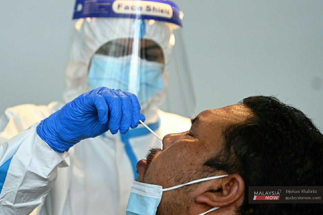 A health worker takes a nasal swab to be tested for Covid-19 in this file picture taken in Kuala Lumpur, February 2021. 